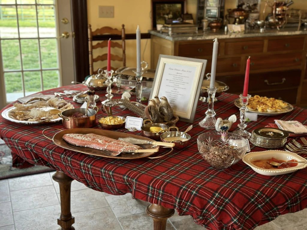At the April 2023 Game Dinner, an elegant table of venison, duck, salmon, steak tartar, quail with burnt apple bourbon purée, anchovy eggs, cheeses, breads, and, duck fat veggies and potatoes.
